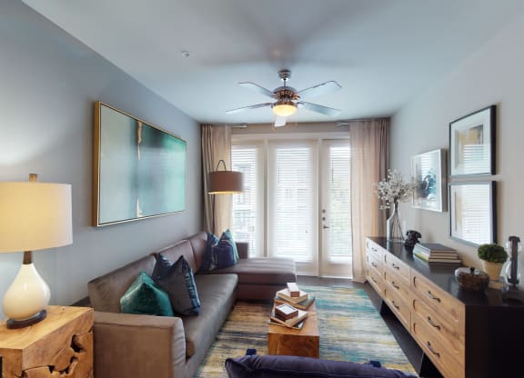 a living room with a ceiling fan and a large window