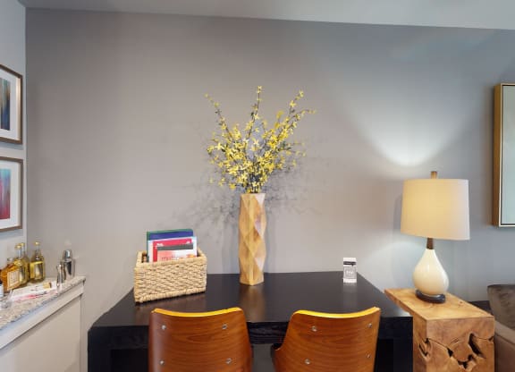 a dining room table with a vase of flowers on top of it