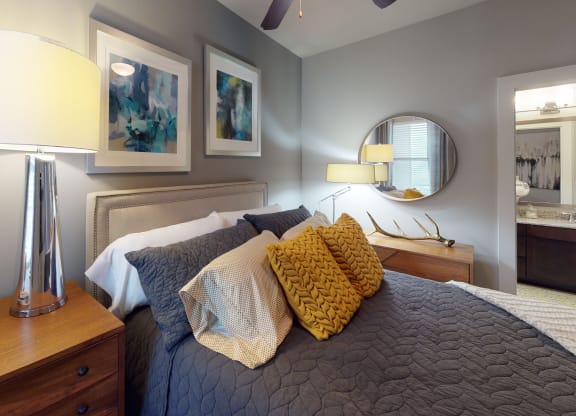 a bedroom with a bed and a dresser with a mirror on the wall