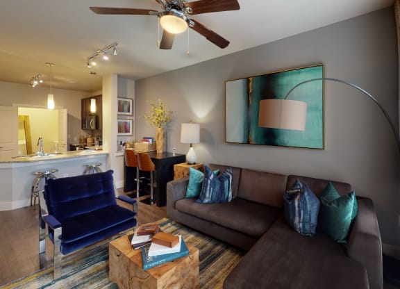 a living room filled with furniture and a ceiling fan