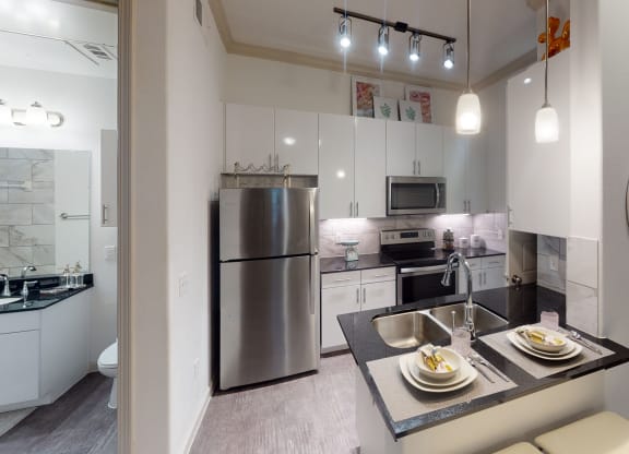 a kitchen with white cabinetry and stainless steel appliances