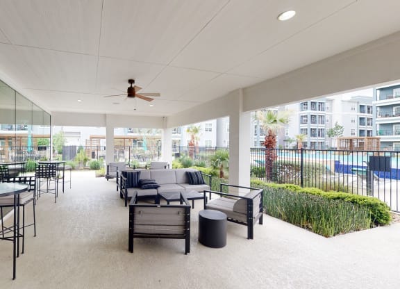 a patio with couches and chairs and a ceiling fan