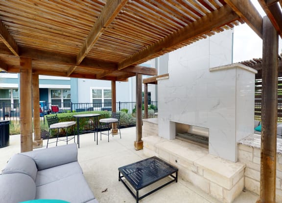 a patio with a fireplace and a pergola
