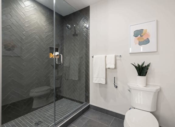a bathroom with a toilet and a sleek shower at Tribeca NOMA apartments