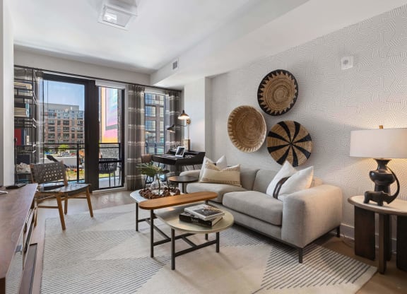 a living room with a couch and a balcony at Tribeca NOMA apartments