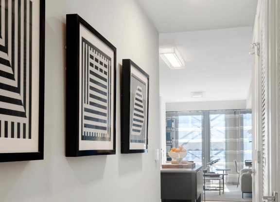 a hallway with art on the wall and a door to a living room at Tribeca NOMA apartments