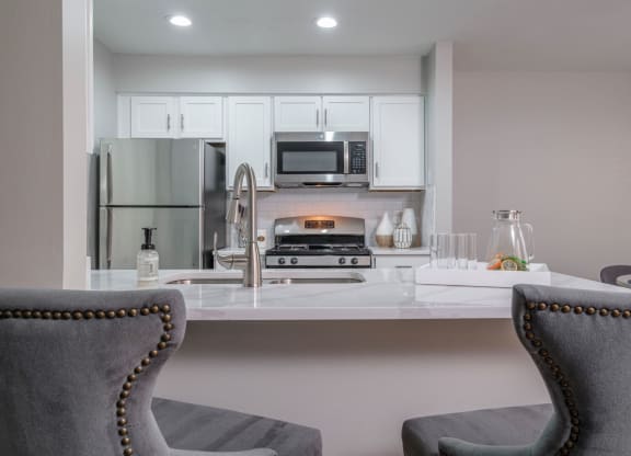 The Residence at Christopher Wren apartments kitchen with stainless appliances and white cabinetry