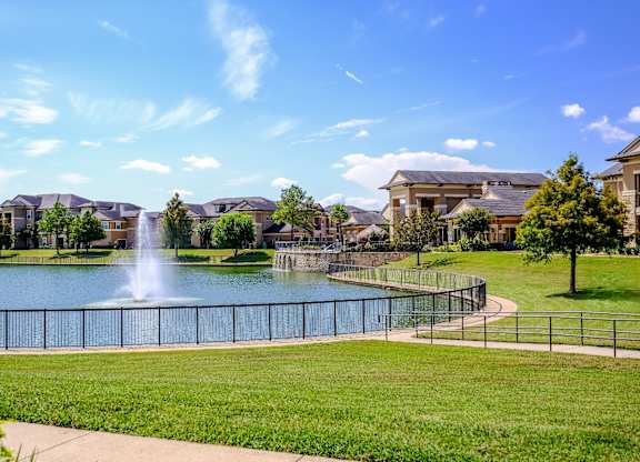 the lake with a fountain at The Falls at Copper Lake apartments