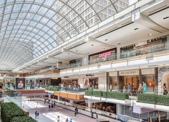 a shopping mall with glass ceilings and people walking