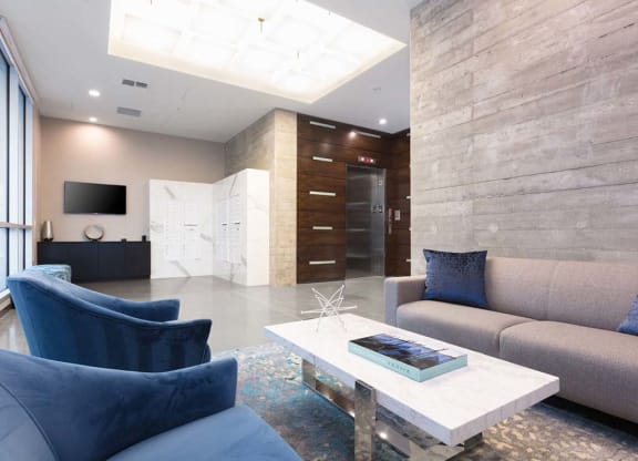 Indoor common area with blue armchairs and grey sofa at Lyric, Walnut Creek, CA