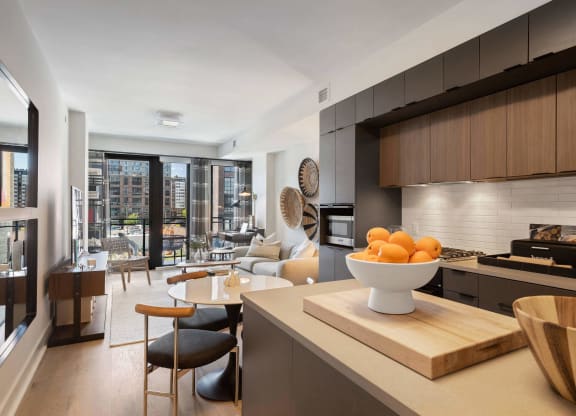 a kitchen with wooden cabinets and a living room in Tribeca NOMA apartments