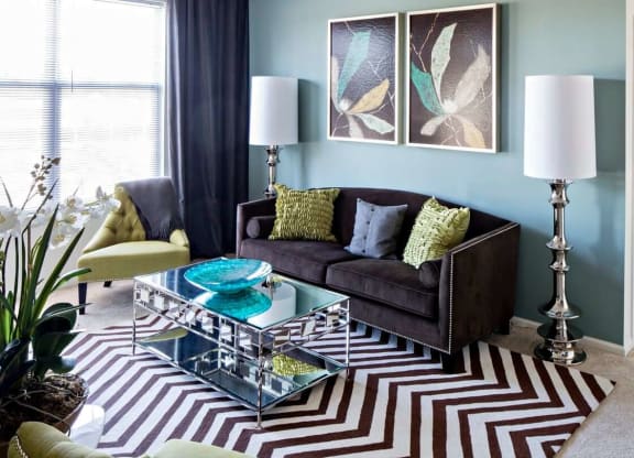 a living room with a couch and a coffee table at Reveal Hackensack apartments