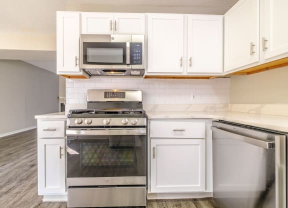 a kitchen with white cabinets and stainless steel appliances