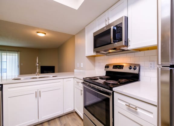 a kitchen with white cabinets and stainless steel appliances