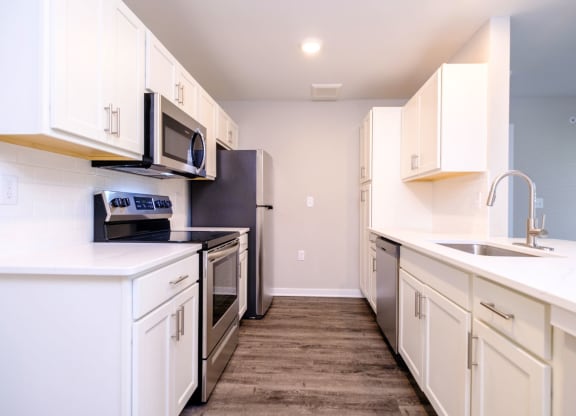 a kitchen with white cabinets and stainless steel appliances