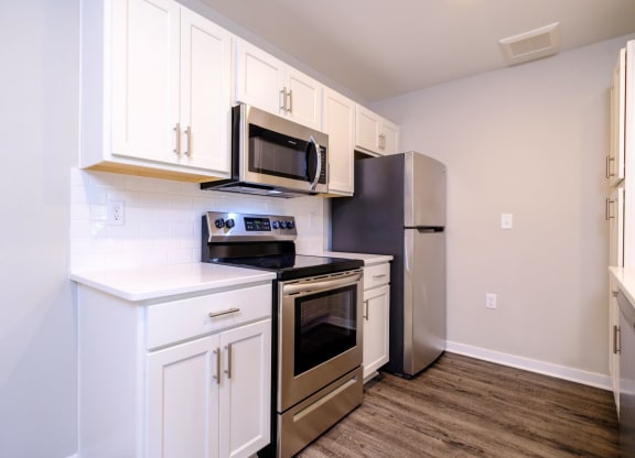 a kitchen with white cabinets and stainless steel appliances