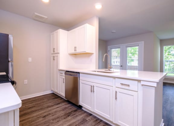 a kitchen with white cabinets and a stainless steel dishwasher