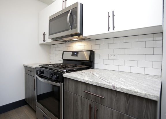 The Edison apartments modern kitchen with stainless appliances and white cabinetry