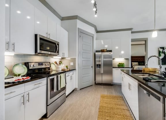 White Cabinetry And Appliances In Kitchen at Berkshire Spring Creek, Garland, Texas