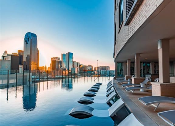 an infinity pool with a Dallas skyline view at The Gabriella apartments
