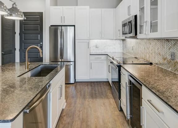 a kitchen with white cabinets and a stainless steel appliances at The Gabriella apartments