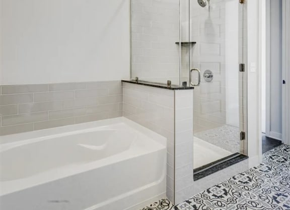 a luxury bathroom with soaking tub and glass surround shower at The Gabriella apartments