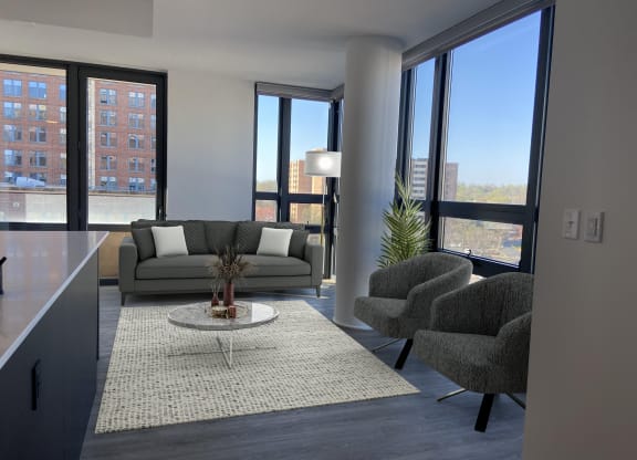 a living room with a gray couch and two chairs at The Millennium, Arlington