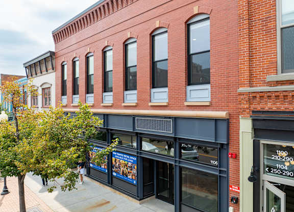 A red brick building with a blue awning and a sign that reads 1106.