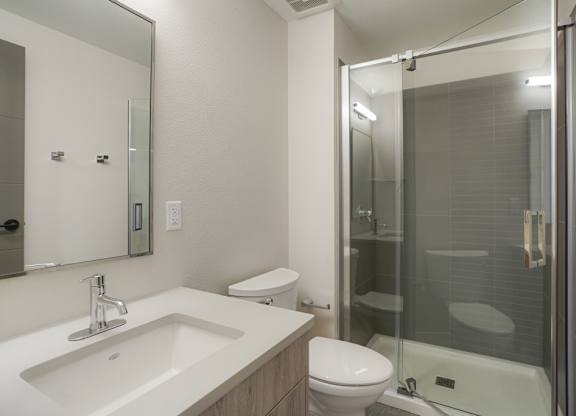 A modern bathroom with a sink, toilet, and shower at The Avenue Lofts Golden Apartments, Golden 80401