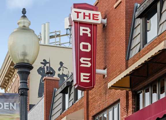 The Rose is a red building with a sign on it at The Avenue Lofts Golden Apartments, Colorado
