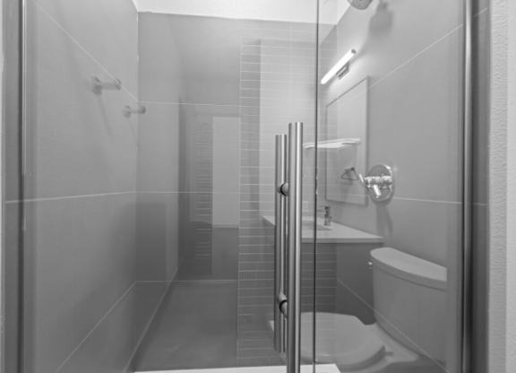 A bathroom with a toilet, sink, and shower at The Avenue Lofts Golden Apartments, Colorado