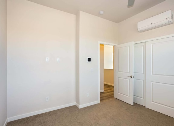 Interior view of open floor plan bedroom with door at Brownstones at Palisade Park, Broomfield, 80023