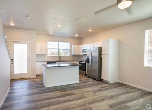 open floor plan living room with granite kitchen island at Brownstones at Palisade Park, Broomfield