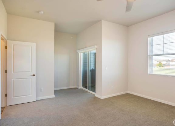 bedroom with doors leading to patio at Brownstones at Palisade Park, Broomfield, 80023