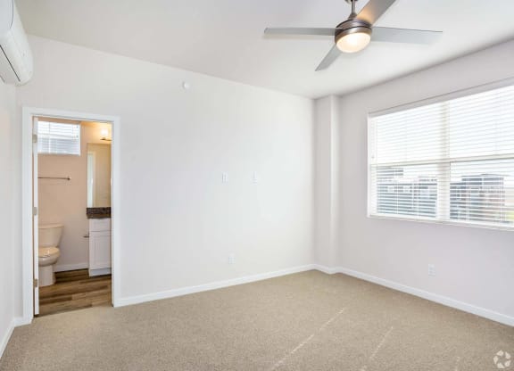 Bedroom with attached bath and windows with open floorplan at Brownstones at Palisade Park,  Colorado