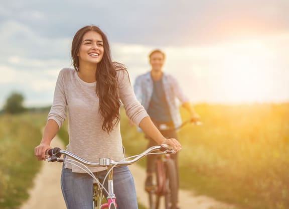 a woman riding a bike with a man at Brownstones at Palisade Park, Broomfield, 80023