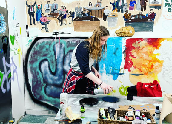 a woman painting in an art studio at The Lofts at 5 Lyon, in downtown Grand Rapids, MI