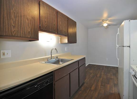 A kitchen with brown cabinets and a white fridge.