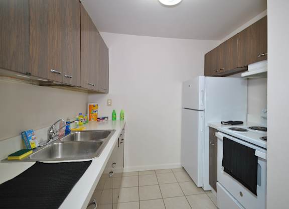 A kitchen with white appliances and brown cabinets.