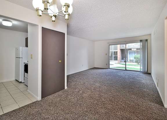 A room with a brown carpet and a chandelier.