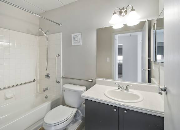 A white toilet sits next to a white sink in a bathroom.