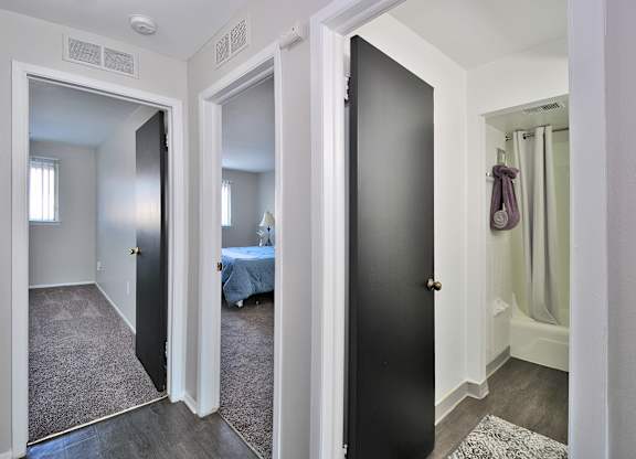 Comfortable bedroom at Woodcrest Apartments in Westland, MI featuring soft carpet flooring, a large closet, and peaceful natural light.