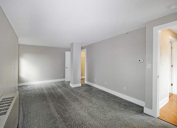 A room with a carpet floor and white walls.