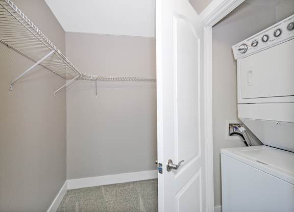 A white oven is in a kitchen next to a closet.