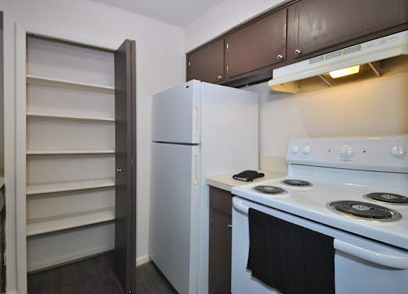 A white refrigerator and stove in a kitchen with brown cabinets.