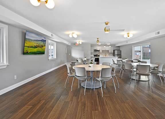 Resident clubhouse with comfortable seating, community tables, and bright natural light at Warren Woods Apartments in Warren, MI.