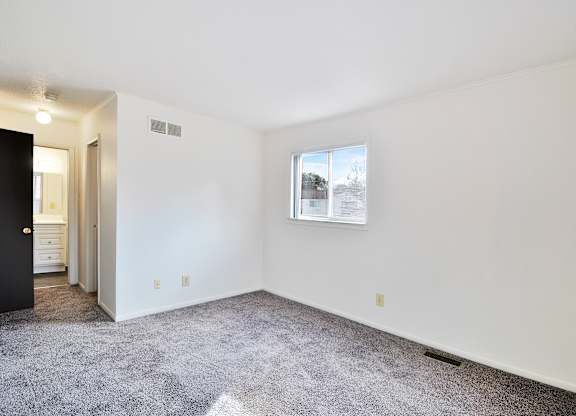 A room with a carpeted floor and a picture on the wall.