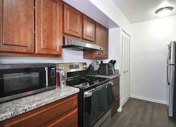 A kitchen with wooden cabinets and black appliances.
