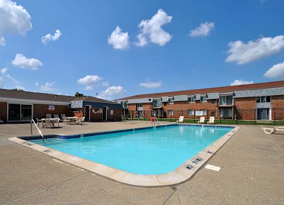 A large swimming pool in front of an apartment building at Warren Woods in Warren, MI