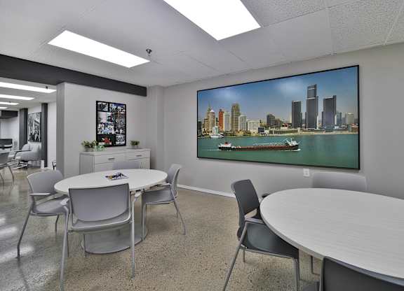 A conference room with a large screen displaying a city skyline.